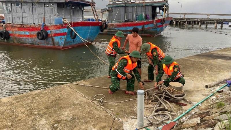 Lực lượng vũ trang thành phố Huế giúp người dân neo đậu tàu thuyền tránh bão. (Ảnh: VÕ TIẾN)