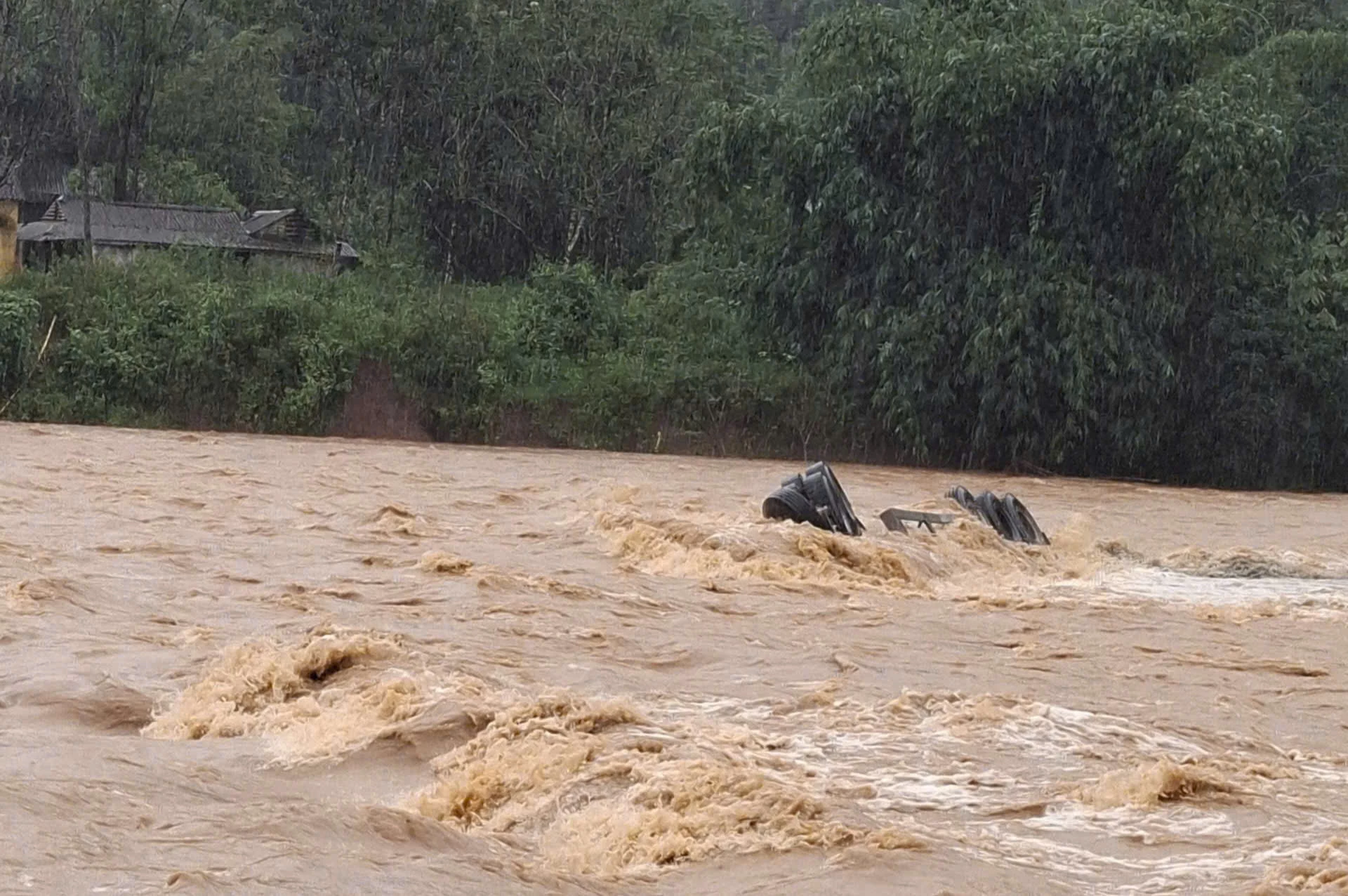 Nước lũ quá lớn đã cuốn trôi xe container cùng tài xế - Ảnh: L.T
